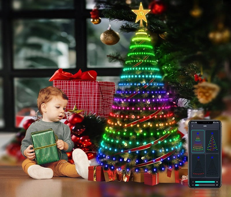 Dziecko przy choince z kolorowymi lampkami LED i telefonem z aplikacją